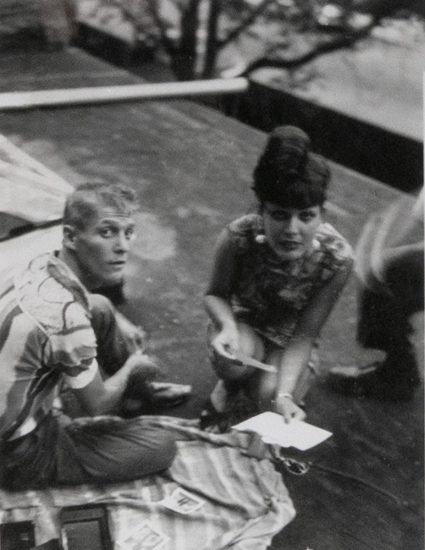 This black and white photograph shows a man and a woman crouching on the ground.
