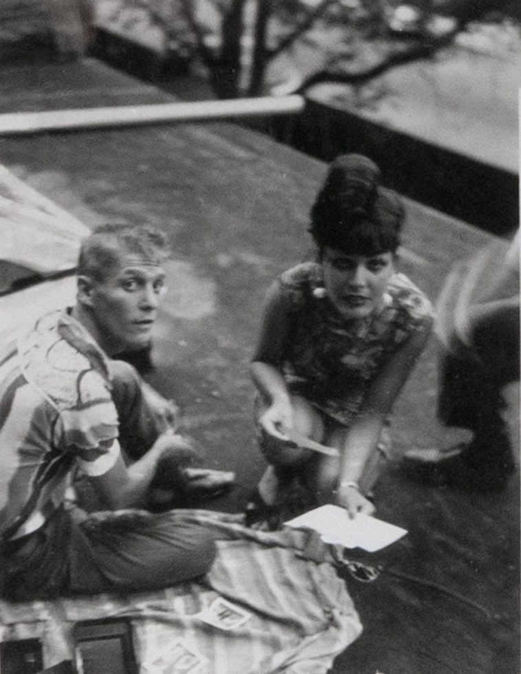 This black and white photograph shows a man and a woman crouching on the ground.