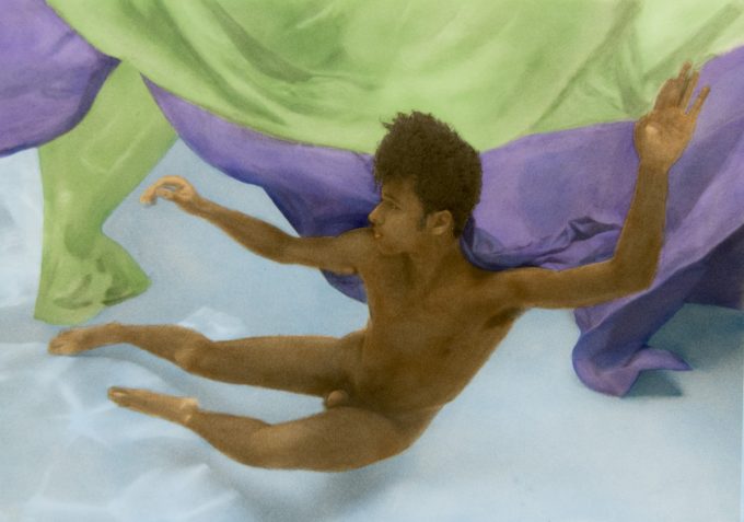 This photograph shows a man floating underwater in a pool with billowing green and purple fabric.