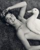 This is a black and white photograph of a shirtless man and a duck.