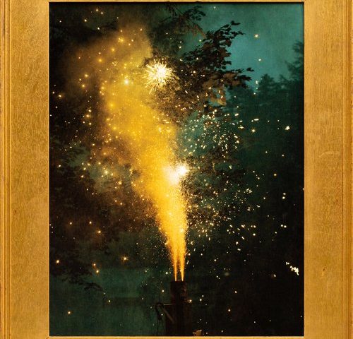 This framed color photograph shows sparks flying into the air in a plume of yellow.