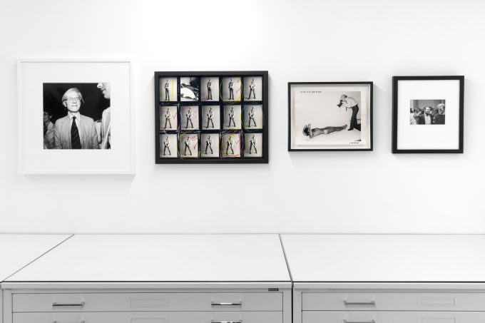 This photograph shows framed black and white photographs on the walls of a gallery.