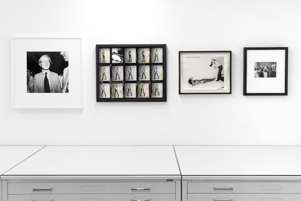 This photograph shows framed black and white photographs on the walls of a gallery.