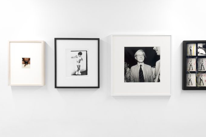 This photograph shows a series of black and white photographs hanging on the walls of a gallery.