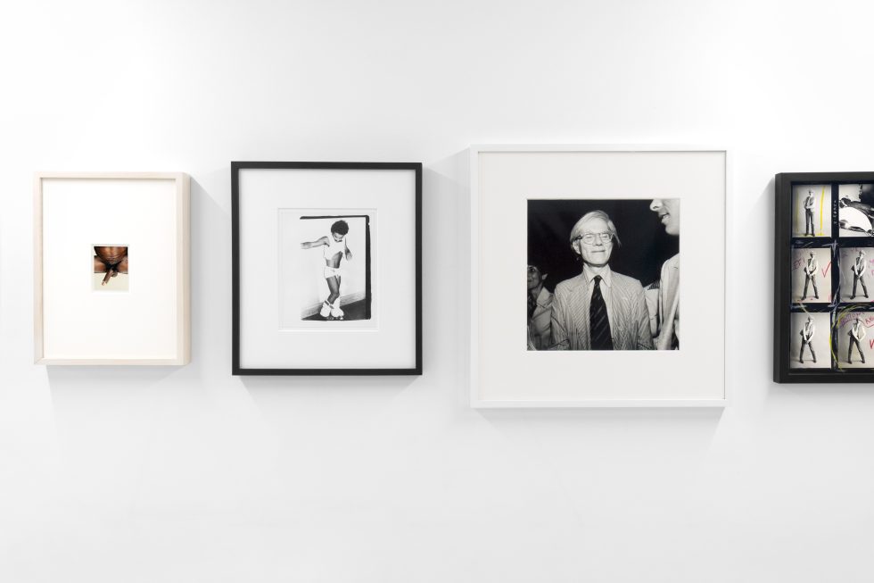 This photograph shows a series of black and white photographs hanging on the walls of a gallery.