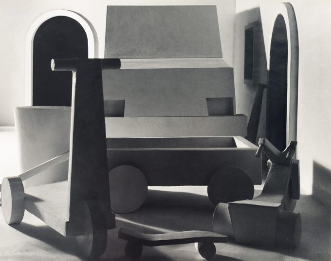 This black and white photograph shows a large typewriter sitting in an open room.