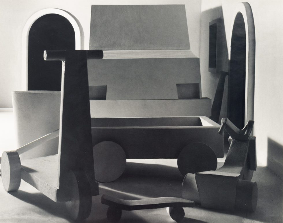 This black and white photograph shows a large typewriter sitting in an open room.