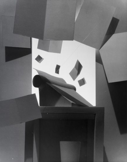 This black and white photograph shows a typewriter with papers flying put of the top.