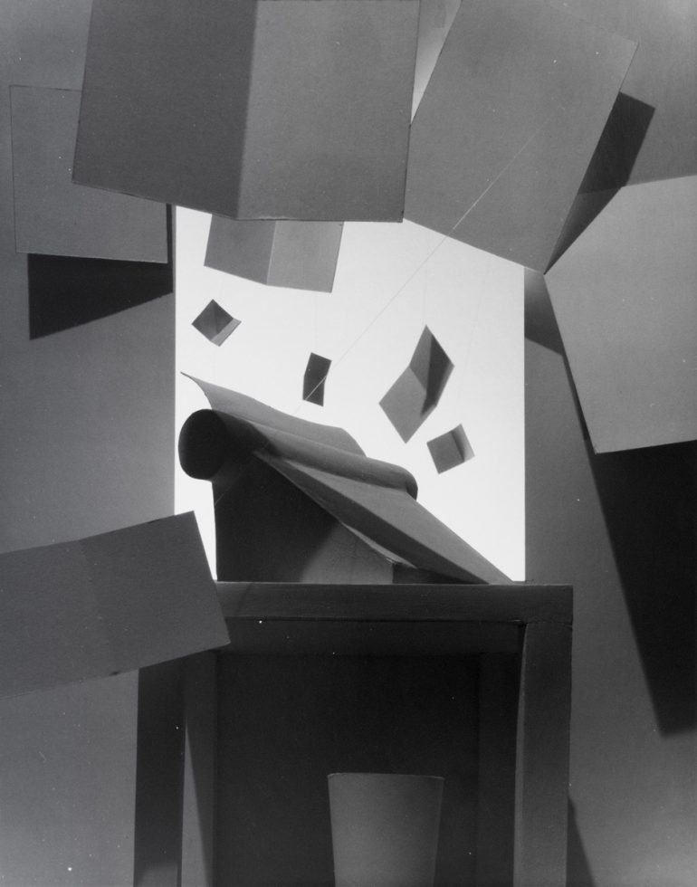 This black and white photograph shows a typewriter with papers flying put of the top.