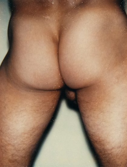 A color photograph of a nude man's backside.