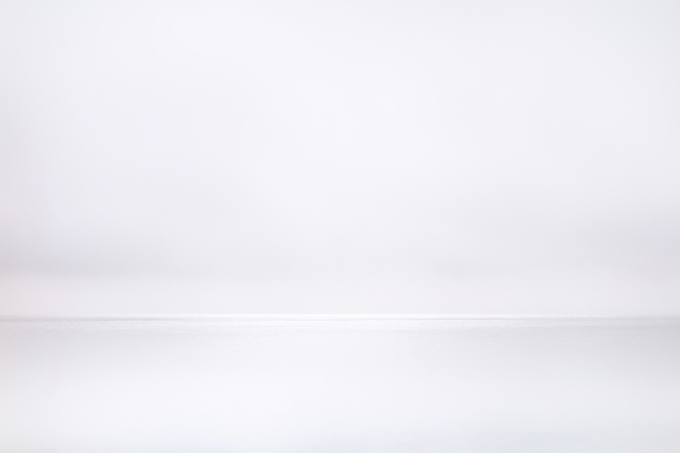 This photograph shows grey water meeting grey horizon on an ocean.