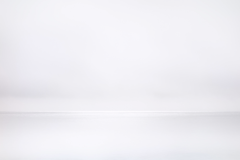 This photograph shows grey water meeting grey horizon on an ocean.