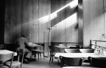 This black and white photograph shows a room lit by streaks of light emerging from a window