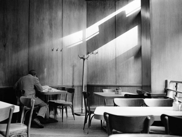 This black and white photograph shows a room lit by streaks of light emerging from a window