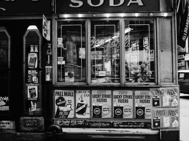 This black and white photograph shows the exterior of a shop.