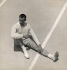 This black and white photograph shows a man in shirts sitting on a court. He is seen from above.